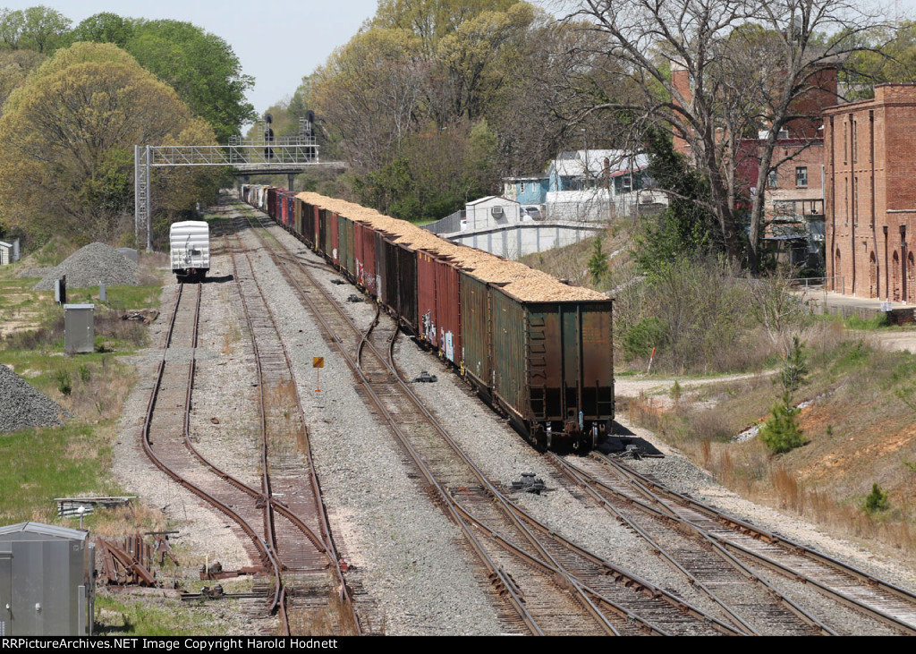 CSX train L619-05 heads south with loaded woodchip hoppers on the rear